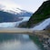 Two people walking on a shore near Mendenhall Glacier and Nugget Falls
